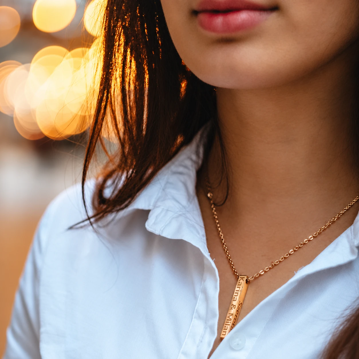 An engraved Namely pendant being worn